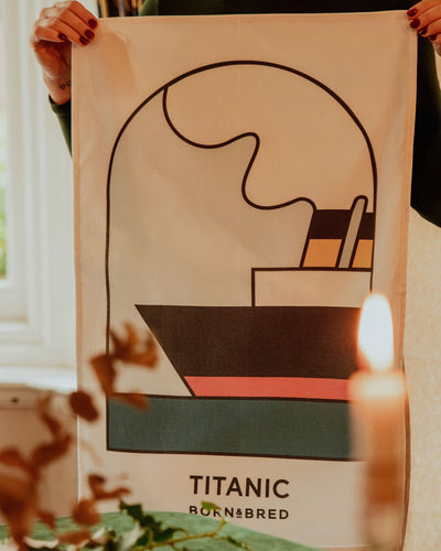 Person holding a poster of the Titanic with decorative elements in the background